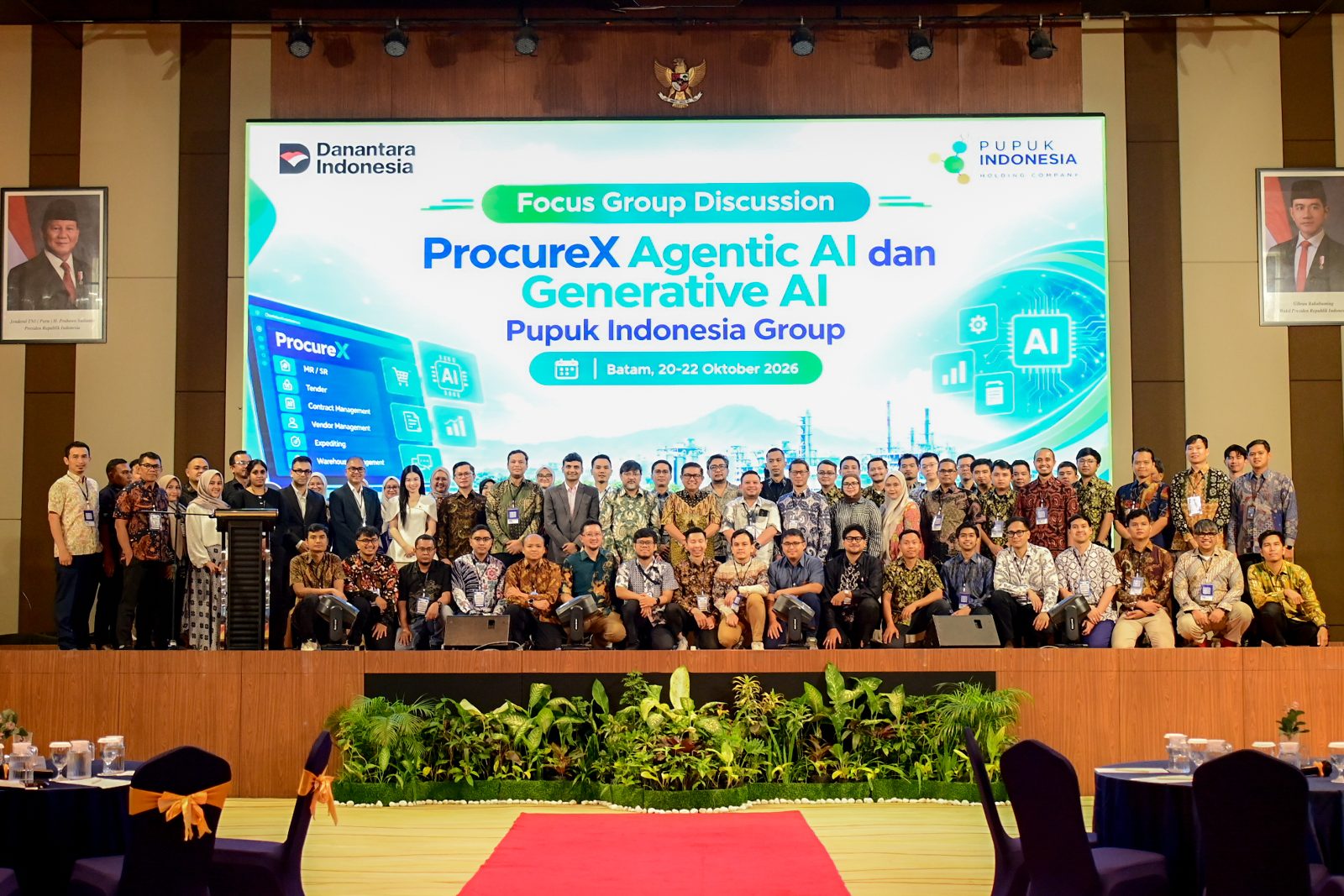 Group photo of the workshop participants on stage in front of the event banner, Focus Group Discussion, Agentic AI and Generative AI, Pupuk Indonesia Group.