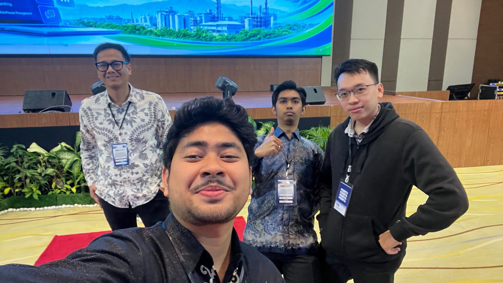 Selfie of four team members in the event hall.